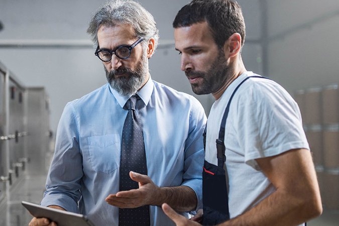 Photo of two men looking at a tablet