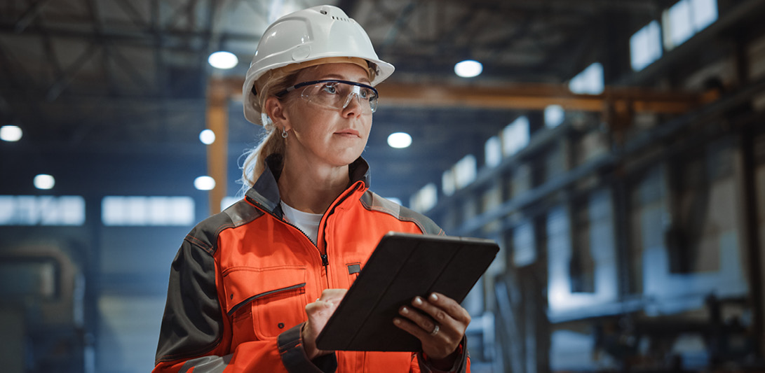 Frau in Arbeitskleidung mit Tablet