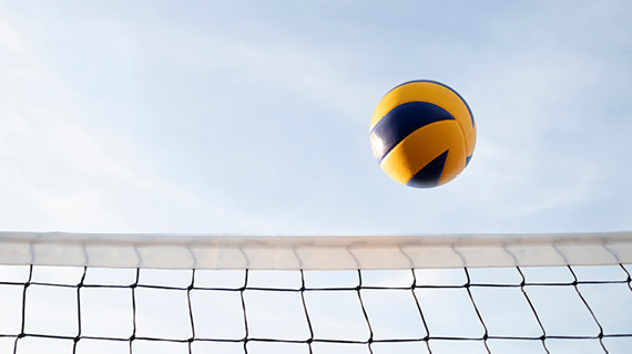 Ein Volleyball fliegt über ein Netz